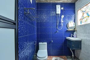 OYO Home 90332 Jentayu Homestay Pontian في بونتييان كيتْشيل: حمام من البلاط الأزرق مع مرحاض ودش