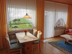ein Esszimmer mit einem Tisch und einem Fenster in der Unterkunft Haus Juist - Schillig in Wangerland