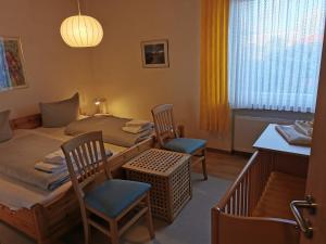 Zimmer mit 2 Betten, einem Tisch und Stühlen in der Unterkunft Haus Juist - Schillig in Wangerland