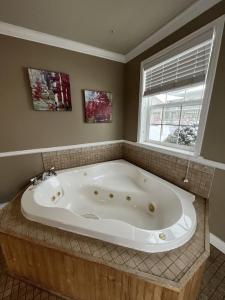 La salle de bains est pourvue d'une grande baignoire et d'une fenêtre. dans l'établissement Mt Olympus Cabin, Cozy 1 bedroom cabin Great for couples, à Estes Park