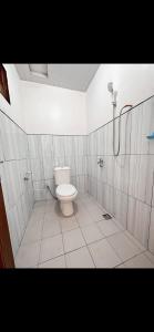 a bathroom with a toilet and a shower at Madinna Villa Dieng in Dieng