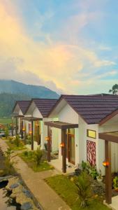 a row of houses with a mountain in the background at Madinna Villa Dieng in Dieng