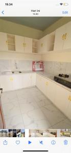 a kitchen with white cabinets and white tile floors at Madinna Villa Dieng in Dieng