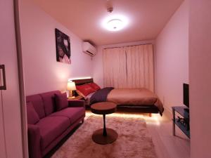 a small bedroom with a bed and a couch at KIKI HOUSE 新小岩 in Tokyo