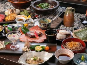 uma mesa com muitos tipos diferentes de alimentos sobre ele em Bettei Fujiya em Miyajima