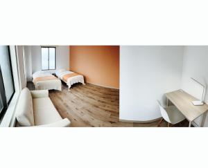 a room with two beds and a couch at CABIN Nozawaonsen in Nozawa Onsen