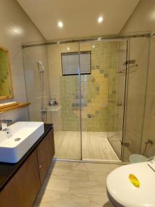 La salle de bains est pourvue d'une douche et d'un lavabo. dans l'établissement Miao Home, à Fanlu