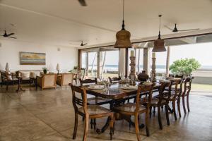 una sala da pranzo con un lungo tavolo e sedie di Kabalana House by Ceilao Villas ad Ahangama