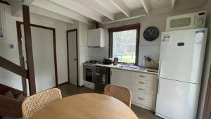 a kitchen with a table and a white refrigerator at Alpine Retreat in Dinner Plain