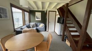 a living room with a table and a couch at Alpine Retreat in Dinner Plain