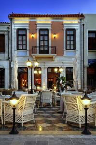 un restaurante con mesas y sillas frente a un edificio en Civitas Suites Hotel, en Rethymno