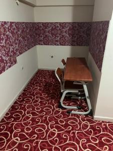 une salle à manger avec une table et des chaises sur un tapis rouge dans l'établissement Ankara apart Hostel 1, à Altındağ