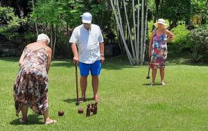 deux femmes et un homme jouant au croquet dans l'établissement Abalone Resort, à Candidasa