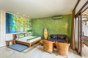 een slaapkamer met een bed en een bank bij Pearl Sunset Resort in Gili Trawangan