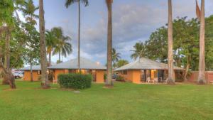 une maison avec des palmiers en face d'une cour dans l'établissement BIG4 Lucinda Wanderers Holiday Park, à Lucinda