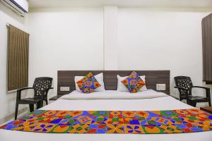 - une chambre avec un lit et une couverture colorée dans l'établissement FabExpress Aditya Regency-Near Railway Station-Bhopal, à Bhopal
