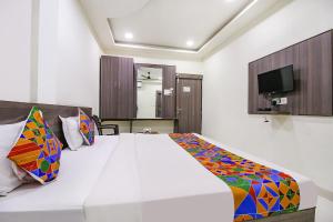 - une chambre avec un lit blanc et une télévision dans l'établissement FabExpress Aditya Regency-Near Railway Station-Bhopal, à Bhopal