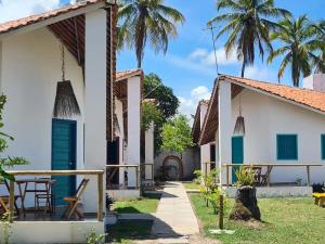 uma vista para o pátio de uma casa com palmeiras em Chalés Jardins dos Cajueiros em Tamandaré