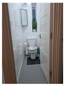 BABUS INTL في Cranford: حمام ابيض مع مرحاض ونافذة