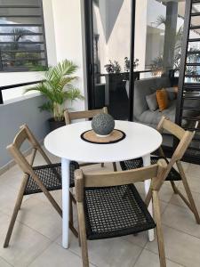 a white table and chairs in a living room at Studio Kooka nui - Private apartment in Papeete