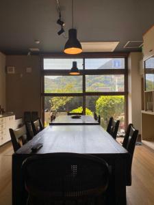 a large dining room table with chairs and a large window at Share Hotel 198 Beppu in Beppu