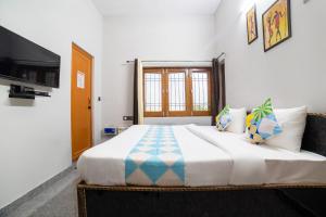a bedroom with a large bed and a television at OYO Home Gautam Homestay in Dehradun