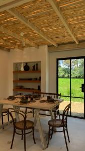 una sala da pranzo con un grande tavolo in legno e sedie di La Casa de la Huerta a Tarija