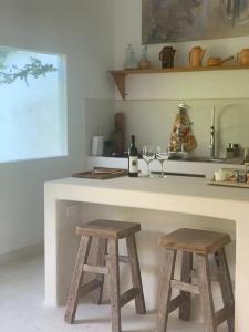 cocina con encimera con 2 taburetes de madera en La Casa de la Huerta, en Tarija
