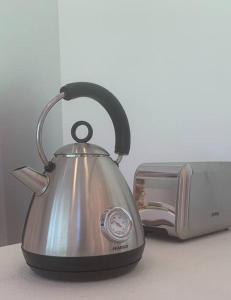 a tea kettle on a counter next to a toaster at La Casa de la Huerta in Tarija