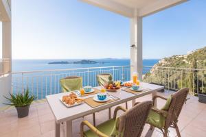 アフィオナスにあるPanorama Apartmentsの海を見渡すバルコニーにテーブルと朝食用の食材を用意しています。