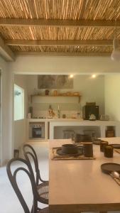 a dining room with a table and chairs and a kitchen at La Casa de la Huerta in Tarija