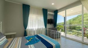 una camera da letto con un letto e una grande finestra di Takamakasky Villas a Takamaka