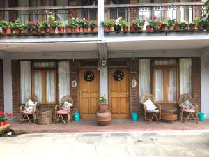 un grupo de sillas de mimbre sentadas frente a un edificio en Roots Shoots & Beds en Kalimpong