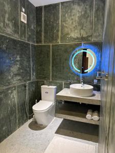 a bathroom with a toilet and a sink and a mirror at Ami Mirissa in Mirissa