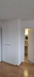 une pièce vide avec des portes blanches et une cuisine dans l'établissement EMANUEL, à Nidau