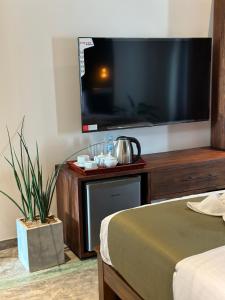 a bedroom with a large flat screen tv on a wall at Ami Mirissa in Mirissa