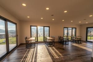 Habitación con mesas, sillas y ventanas grandes. en Tolstoy'un Bisikleti Otel, en Gokceada Town