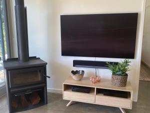 a living room with a television and a wood stove at Moriarty Retreat - couple's luxe getaway in Yallingup