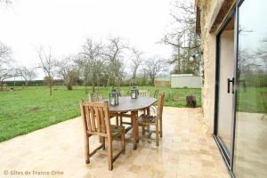 Une table et des chaises en bois sont disponibles sur la terrasse. dans l'établissement Marguerite, à Colombiers