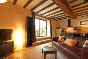 a living room with a leather couch and a television at Marguerite in Colombiers