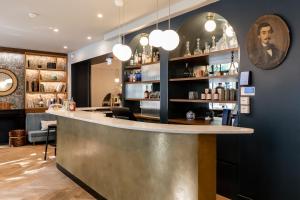 a bar in a restaurant with lights on the wall at Hôtel Léopold - Orso Hotels in Paris