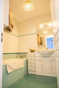 a bathroom with a tub and a sink and a mirror at Côté mer in Marseille