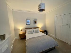 a bedroom with a bed with two night stands and two lamps at Traditional Cottage in West Kilbride Village in Seamill