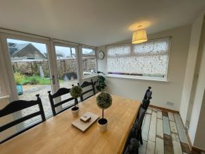 a dining room table with two potted plants on it at Traditional Cottage in West Kilbride Village in Seamill