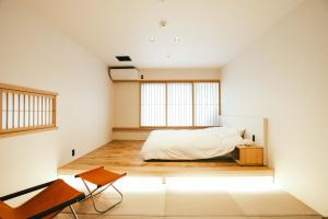 a bedroom with a bed on a wooden floor at SATOYAMA STAY Nino-Machi in Furukawachō