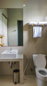 a bathroom with a sink and a toilet and a mirror at Abisha Villa Jimbaran in Jimbaran