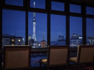 a room with two chairs and a view of a city skyline at Asakusa View Hotel Annex Rokku in Tokyo