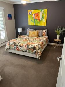 a bedroom with a bed with a painting on the wall at Quiet family retreat getaway - Wildlife Park, Sovereign Hill, Kryall Castle and city at your door - modern apartment, 8 guests in Ballarat