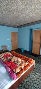 1 dormitorio con cama con edredón en Nakpo Homestay en Leh
