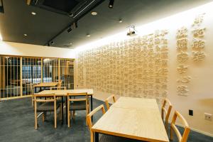 a dining room with wooden tables and chairs at SATOYAMA STAY Nino-Machi in Furukawachō